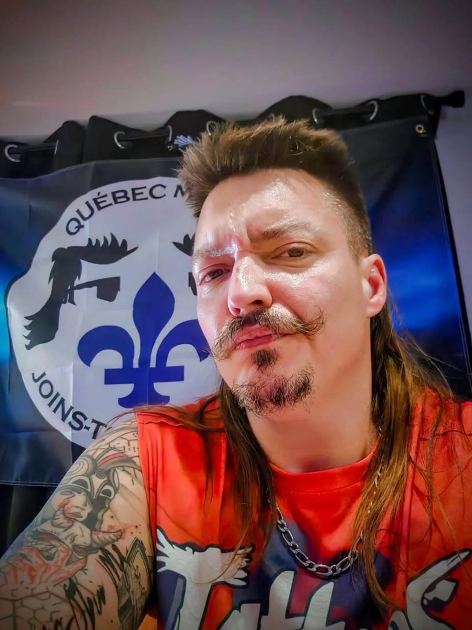 J-P Roy, fondateur de Québec Mulet, devant le drapeau du mouvement